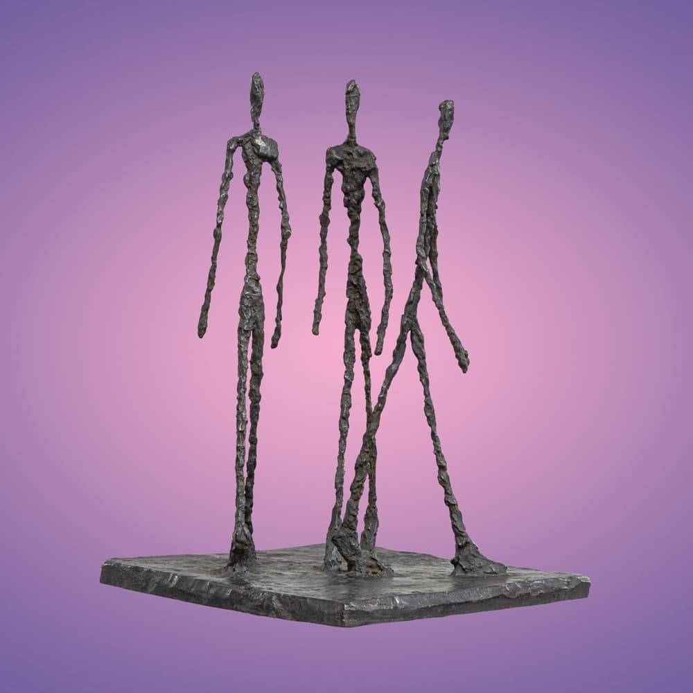 Bronze-Skulptur mit drei langen, sehr dünnen Menschen vor lilafarbenem Hintergrund