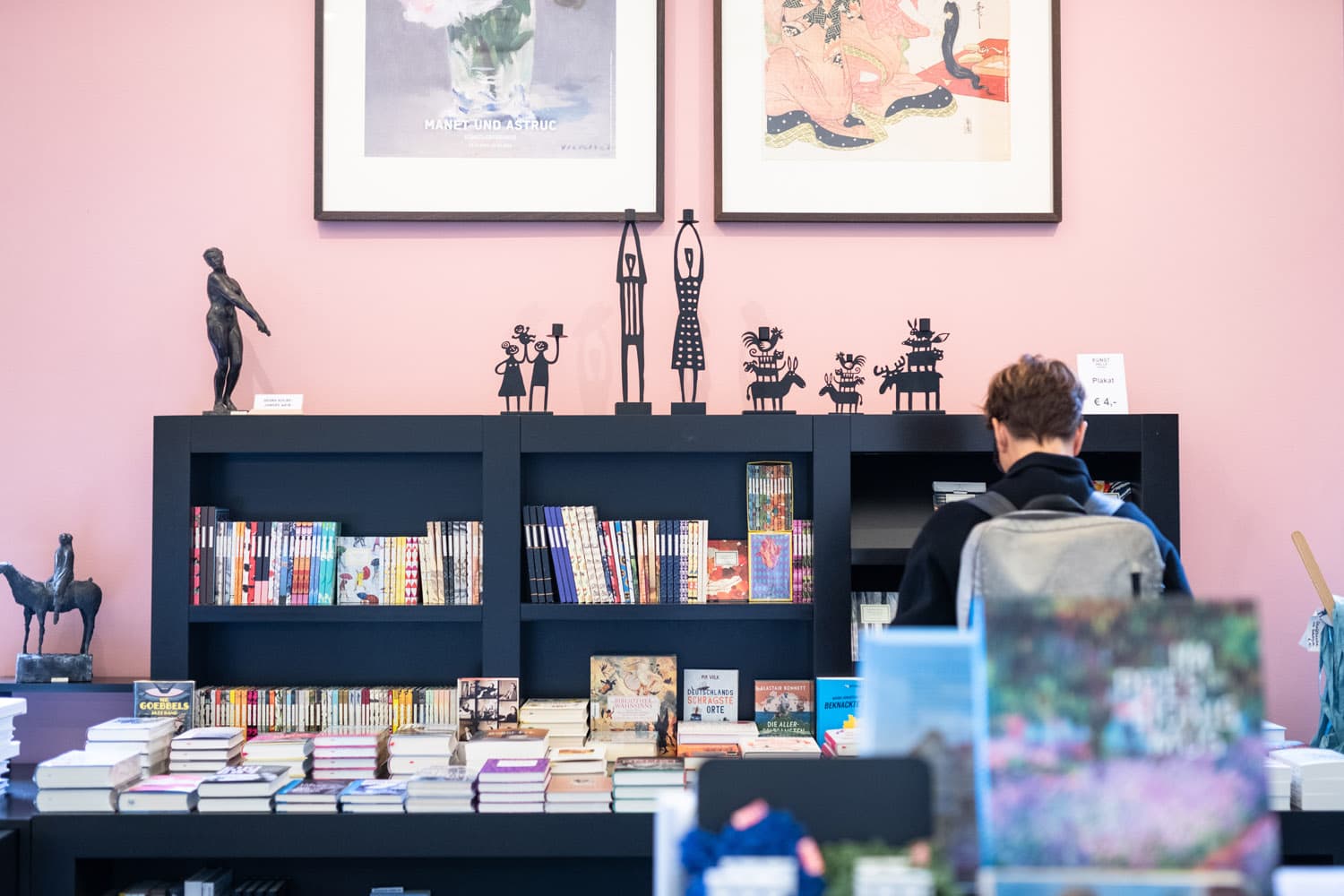 Regal mit Büchern und kleinen Skulpturen